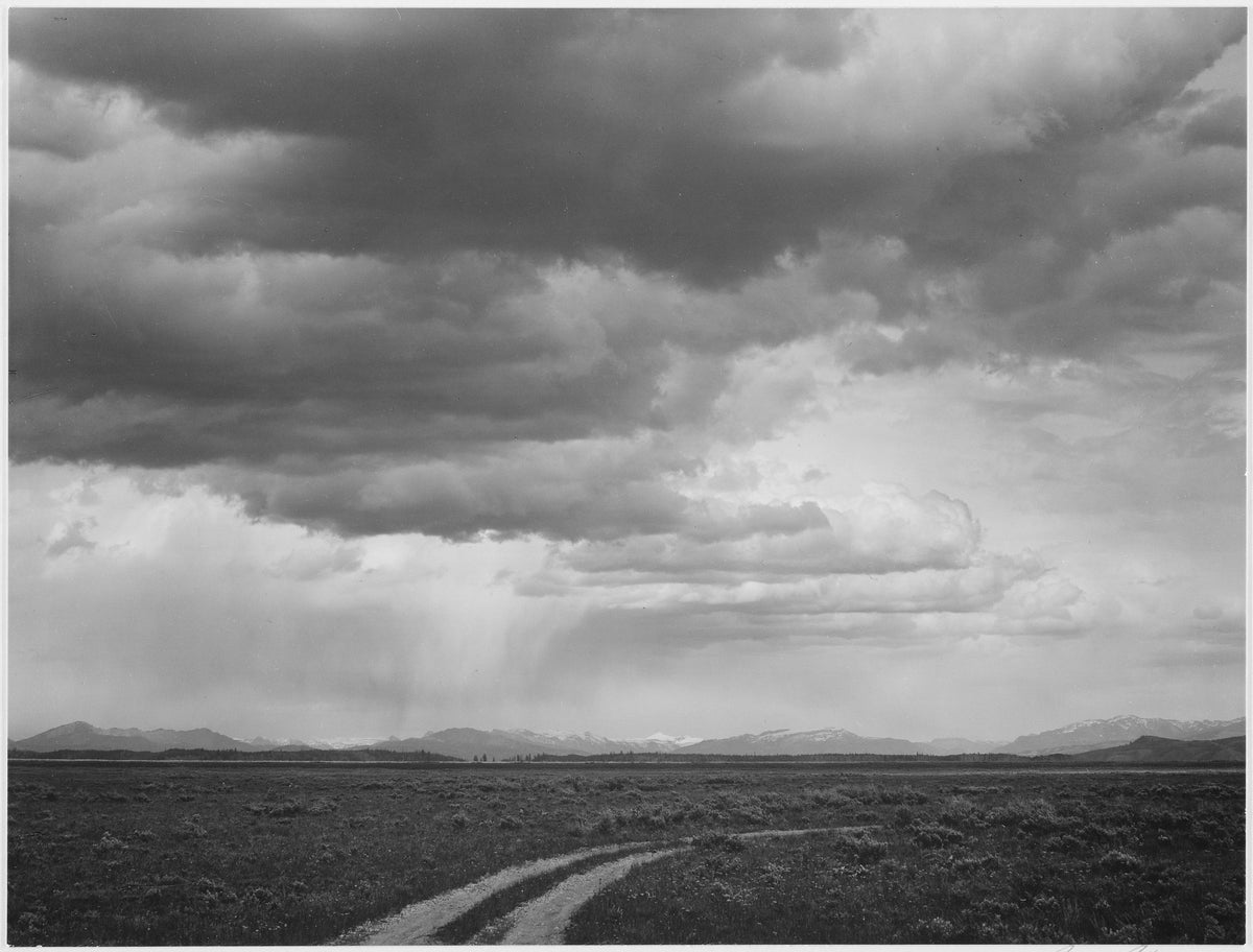 Ansel Adams photograph of a roadway under clouds near Grand Teton